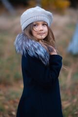 A beautiful smiling little girl with blue eyes in the park