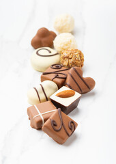 Chocolate candies assortie. Elegant composition of sweets with different fillings. Soft focus. Vertical photography.