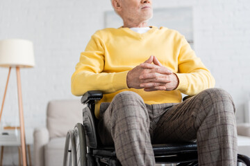 Fototapeta premium Cropped view of pensioner sitting in wheelchair at home.