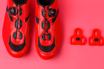 Cycling Ideas. Pair of New Red Cycling Shoes Placed Together With Red Cleats Over Pink Coral...