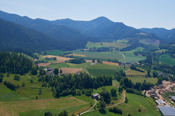 View green meadow and farm fields, forest in the mountains