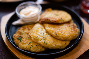 Fried grated potato pancakes with sour cream