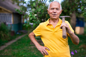 Naklejka na ściany i meble Senior man standing in yard of his country house
