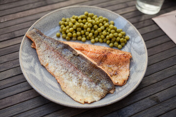 Appetizing baked trout fillets with green peas
