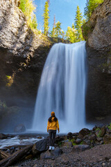Beautiful waterfall in Canada, couple visit Helmcken Falls, the most famous waterfall in Wells Gray...