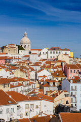 Fototapeta na wymiar Colorful houses and the dome of the Santa Engracia church in Lisbon, Portugal