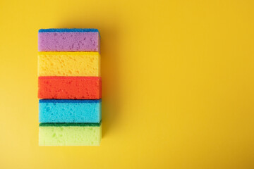 sponges for washing dishes, multi-colored bright tools on a yellow background