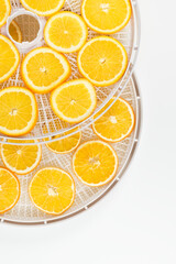 fresh orange slices in a tray for making dried fruits on a white background, close-up, top view