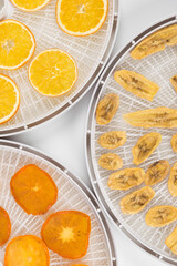 bananas, oranges and persimmons in dried fruit preparation trays