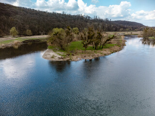 Spring view on river curve with scenic reflection. Zmiyevsky region, Siverskyi Donets River in Ukraine. Cloudy sky above blue rippled water in rural countryside