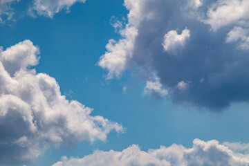Naklejka na ściany i meble Fluffy white high clouds on bright blue sky, cloudscape background. Skyscape natural heavenly scenery