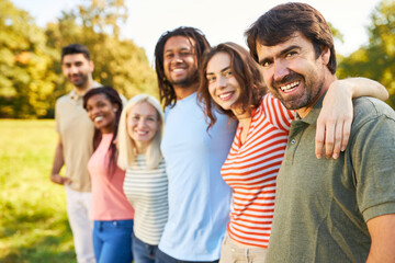 Diverse glückliche Gruppe Freunde umarmen sich in Natur