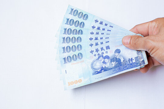 Human hand holding  Taiwan  money isolated on white background.Cash, Taiwan currency, money, Taiwan Coin, Taiwan money,Taiwan Dollar money..