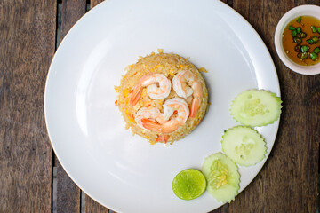Fried rice with shrimp on the wooden table.