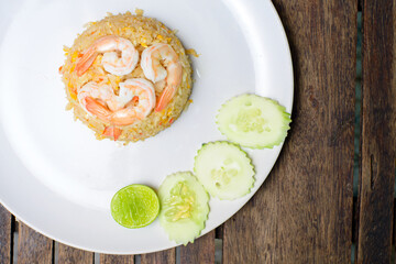 Fried rice with shrimp on the wooden table.