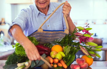 Mature woman arrives from the grocery store and places her shopping bag on the table full of...