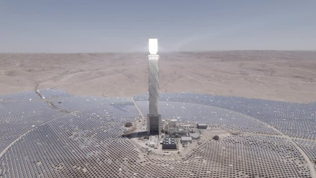 Solar power tower focused sunlight for movable mirrors at the desert sun non time in a cloudless day- slow tracking paralax drone shot (D-LOG)