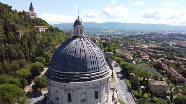 Slowly orbiting and revealing Aerial view of Santa Maria della Consolazione, catholic church. Summer season, blue sky sunny day. Todi Umbria. Italy