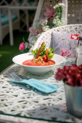 Summer cold watermelon smoothie gazpacho soup, sea blue background with avocado slices, watermelon, lime and herbs