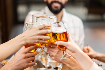leisure, people and celebration concept - close up of happy friends having dinner and drinking beer at restaurant or pub