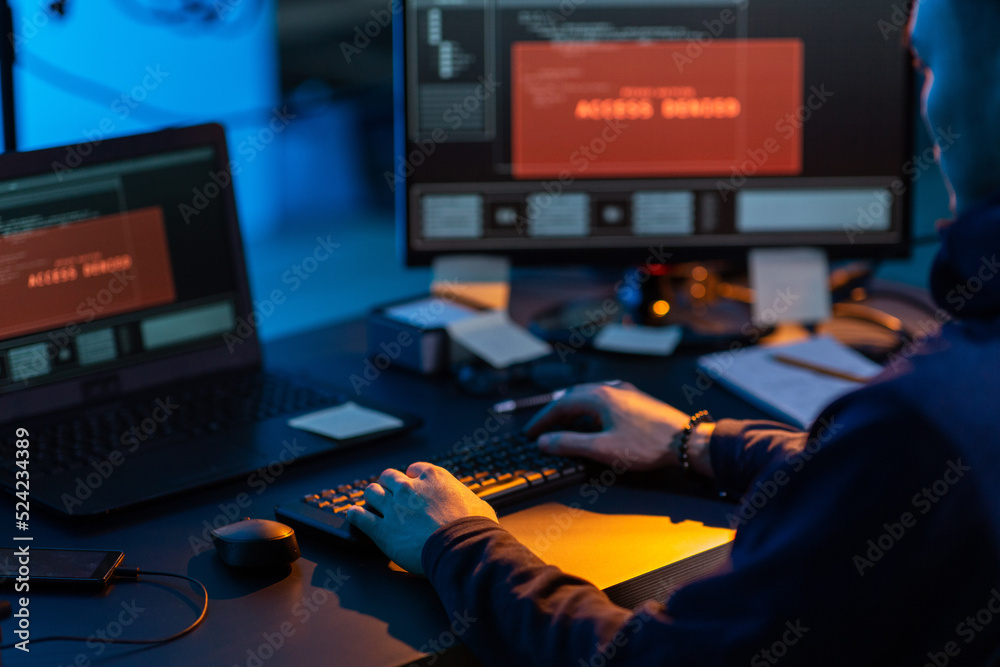 Poster cybercrime, hacking and technology concept - close up of male hacker in dark room writing code or us