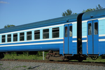 Old Russian suburban passenger train wagon on one way railroad at summer day