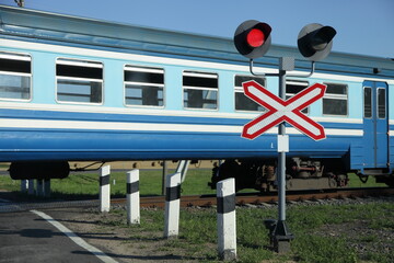 Forbidding red traffic light and roadsign on one way railway crossing on old passenger train wagon...
