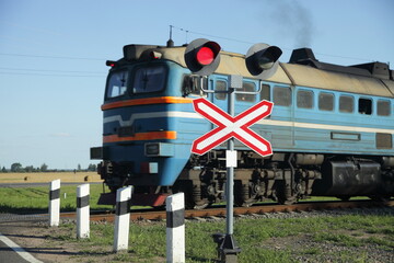 Forbidding red traffic light and roadsign on one way railway crossing on old diesel locomotive...