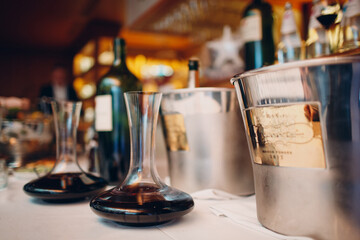 the waiter pours elite red wine into the decanter on the table in the restaurant.