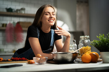 Young woman in kitchen. Beautiful woman making delicious food.
