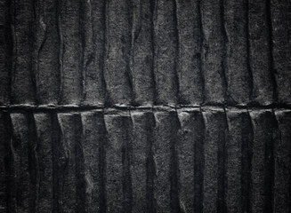 A sheet of black corrugated cardboard texture as background
