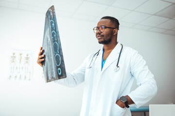Closeup portrait of intellectual man healthcare personnel with white labcoat, looking at full body x-ray radiographic image, ct scan, mri, isolated hospital clinic background. Radiology department
