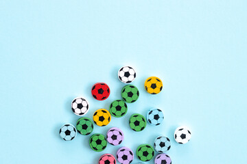 Wooden figures in the form of soccer balls on a blue background. Football time.