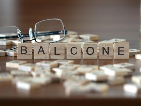 balcone parola o concetto rappresentato da piastrelle di legno su un tavolo di legno con occhiali e un libro