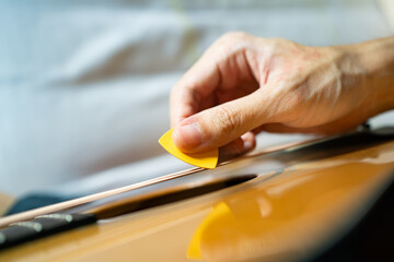 Guitarist playing acoustic guitar with a guitar pick