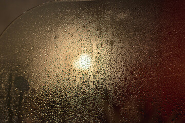 Drops on the glass in the bathroom after taking a shower. Wet glass in the bathroom against a red wall is a selective focus. Blurred background.Fogged glass.