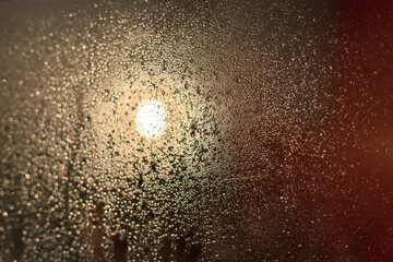 Drops on the glass in the bathroom after taking a shower. Wet glass in the bathroom against a red wall is a selective focus. Blurred background.Fogged glass.