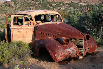 Abandoned  old car in a beautiful  green landscape. 