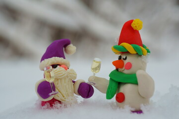 Snowman and Santa Claus holding a glass of champagne in his hand. Christmas toys. A festive event. New Year and Christmas. Fabulous figurines.