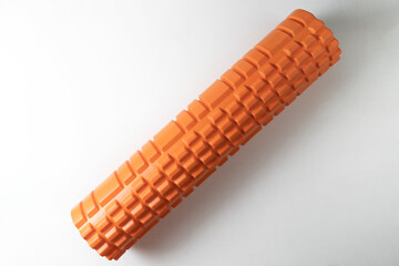 An orange myofascial release roller lying on a white background