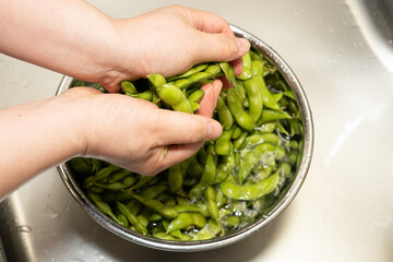 だだちゃ豆をゴシゴシ擦って毛を取り除く作業