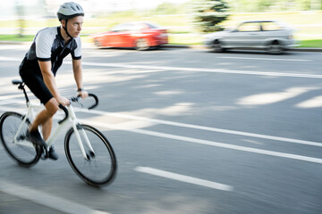 Photo in motion blurred, Male athlete in Gear riding bike for highway workout