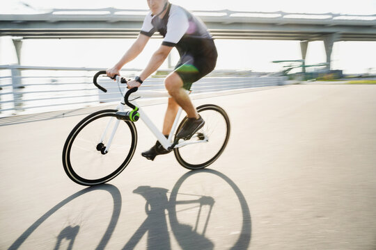 A photo in motion, a man on a road bike in a helmet riding in cycling clothes for training