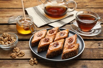 Naklejka na ściany i meble Delicious sweet baklava with walnuts, honey and hot tea on wooden table