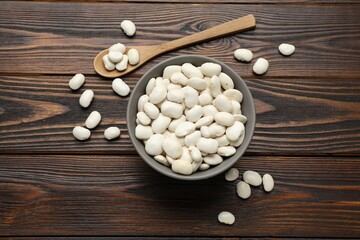 Fototapeta na wymiar Raw white beans on wooden table, flat lay