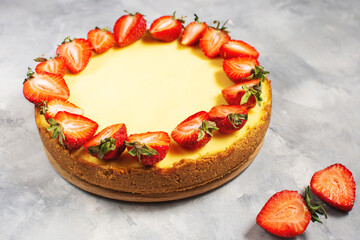 Sweet breakfast, delicious cheesecake with fresh strawberries, homemade recipe on concrete table.