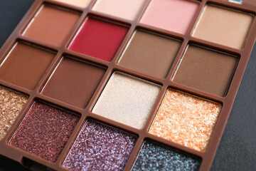 Colorful eyeshadow palette on dark background, closeup