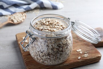 Glass jar with oatmeal on white wooden table