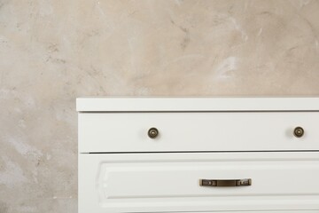 Modern chest of drawers near beige wall