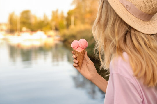Young woman with delicious ice cream in waffle cone outdoors, closeup. Space for text